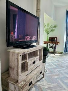 a tv sitting on top of a wooden dresser at Renovated and air-conditioned 2-bedroom apartment with terrace in Saint-Paul-de-Fenouillet