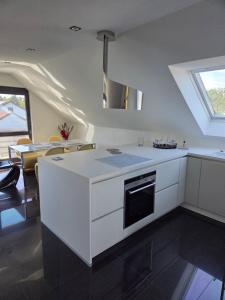 a kitchen with white cabinets and a stove top oven at Vellberg Hideaway - Stilvolle Ferienwohnung in Vellberg, Erholung pur in Vellberg