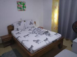 a bedroom with a bed with zebra and zebras at Résidesnce Merveilles M18 in Kribi