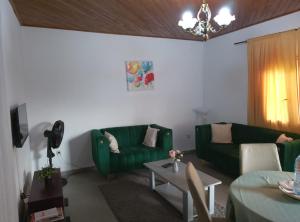 a living room with two green couches and a table at Résidesnce Merveilles M18 in Kribi