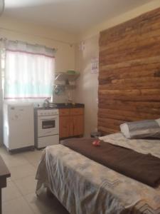 a room with a kitchen with a bed and a stove at Morada do rosa ouvidor in Garopaba