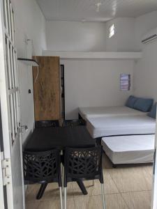 a small room with two beds and a table at Village Galés Maragogi in Maragogi
