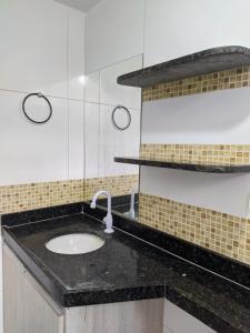 a bathroom with a sink and a black counter top at Village Galés Maragogi in Maragogi