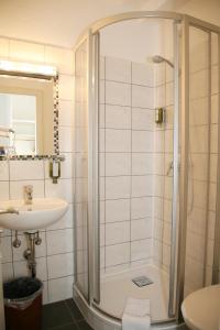 y baño con ducha y lavamanos. en Hotel Pflug, en Ottenhöfen
