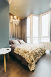 a bedroom with a large bed and a chandelier at ATLANT luxury apartments ТЦ ДЕПОТ in Chernivtsi