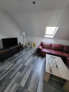 a living room with a red couch and a table at Ferienwohnung Monteurzimmer in Eppelborn