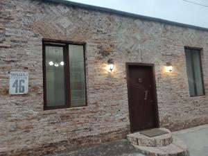 a brick building with a door and a sign on it at Best Host in Sighnaghi