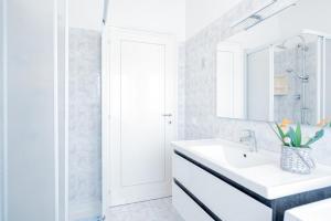 a white bathroom with a sink and a mirror at La Casa delle Orchidee in Mozzagrogna +49 photos