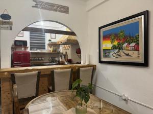 a dining room with a table and a painting on the wall at VSS Rustic in Arecibo - Stylish & Relaxing Escape Near Beaches in Arecibo