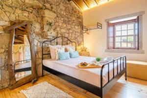 a bedroom with a bed in a stone wall at House Sopo in Vila Nova de Cerveira