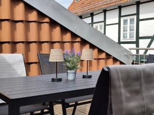 a wooden table with two lamps and two chairs at ApartZ - Celle Altstadt - bis 9 Personen, 3 SZ, Infrarotsauna, Parkplatz, W-LAN, Dachterrasse in Celle