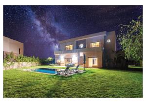a house with a swimming pool at night at Villa Dahlia Jacuzzi, Stove, Pool in Marrakesh +9 photos