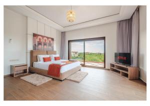 a bedroom with a large bed and a television at Villa Dahlia Jacuzzi, Stove, Pool in Marrakesh