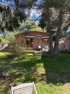 ChampclauseChalet grenouille Domaine de la Mamounette的树荫庭院中的小木屋