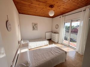 a bedroom with two beds and a large window at Privilegio apartment in Episkopianá