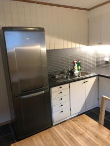a kitchen with a stainless steel refrigerator and a sink at Hamrebakken overnatting in Kvinesdal
