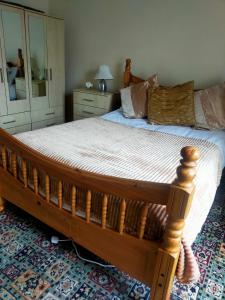 a bedroom with a wooden bed and a mirror at Newly Decorated Spacious room, Women only in Bradford