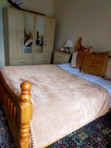 a bedroom with a large bed with a wooden frame at Newly Decorated Spacious room, Women only in Bradford