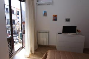 a bedroom with a television on a dresser with a window at Centro storico apartment & Loft - Amnesia Holiday Home in Palermo