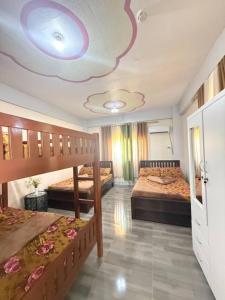 a bedroom with two beds and a purple ceiling at Mountain cove villa in Pagudpud