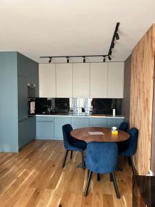 a kitchen with a wooden table and blue chairs at Tutu Kraków Comfort in Krakow +30 photos