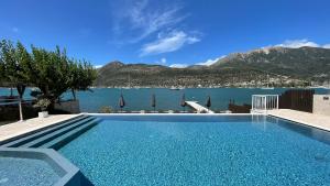 a swimming pool with a view of the water at Seaside Apartments - Adults Only in Yénion