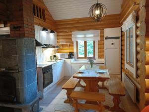 a kitchen with a wooden table and a wooden stove at Kolilla oy, Purnutar A in Kolinkylä