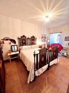a bedroom with a large bed with white sheets at La casa di Nonna Carissima in Villalago
