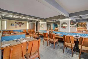 浦那Hotel O Haveli Executive的餐厅里有桌椅的餐厅