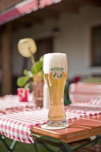 un vaso de cerveza sentado en la parte superior de una mesa en Hotel-Restaurant Zum Hirschhaus, en Ruhpolding