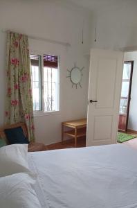 une chambre avec un lit et un miroir au mur dans l'établissement Casa con piscina cerca de Sevilla, à Carrión de los Céspedes