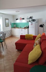 un salon avec un canapé rouge et une cuisine dans l'établissement Casa con piscina cerca de Sevilla, à Carrión de los Céspedes 22 autres photos