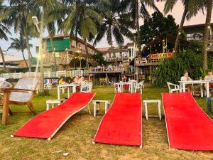 two red slides in front of a restaurant with tables and chairs at Honey beach backpackers in Negombo