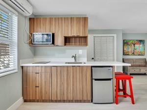 a kitchen with a sink and a red stool at Beachside 1BR Apt – Steps to Hollywood Dania in Dania Beach +19 photos