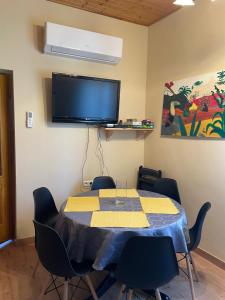 a room with a table with chairs and a flat screen tv at Greenapple Apartman Badacsony in Badacsonytördemic
