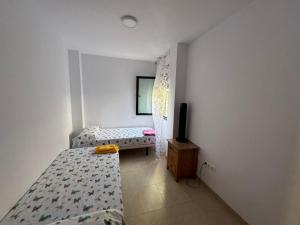 a bedroom with two beds and a tv in it at apartamento vacacional roquetas de mar in Roquetas de Mar