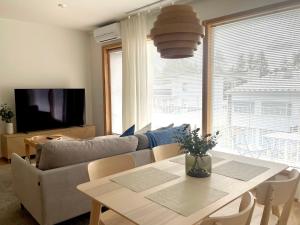 a living room with a table and a couch at Kivikatu Apartment in Rovaniemi