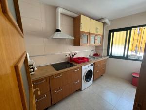 a kitchen with a sink and a washing machine at apartamento vacacional roquetas de mar in Roquetas de Mar