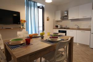 a kitchen with a wooden table with dishes on it at Centro storico apartment & Loft - Amnesia Holiday Home in Palermo