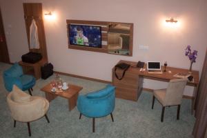 a room with a desk and chairs and a tv at Agropolog Hotel & Spa in Želino