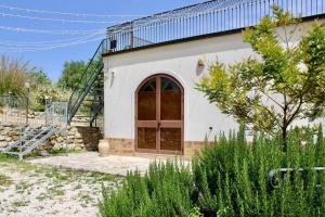 a white building with a wooden door in a yard at Roba Albanisi in Aragona +55 photos