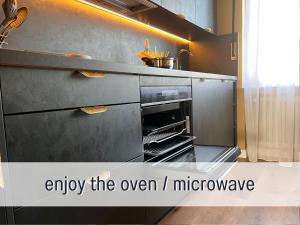 ein Ofen in einer Küche mit der Aufschrift „Genießen Sie die Mikrowelle“ in der Unterkunft SUPERIOR LIVING - luxury and comfort in Bad Oeynhausen + 34 Fotos