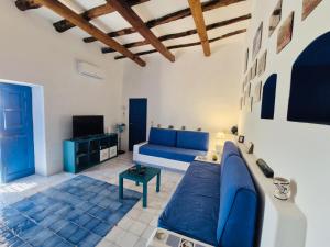 a living room with a blue couch and a tv at Villa Vista Mare a Filicudi in Filicudi