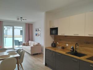 a kitchen with a sink and a table with a dining room at Apartament Wypoczynkowa in Augustów