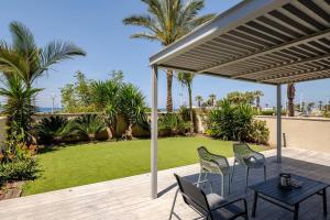 a patio with a table and chairs and a lawn at GW002 Gugel Waves Amazing Seaview & Garden Family Apartments in Nahariyya