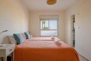 a bedroom with a bed with two towels on it at GW002 Gugel Waves Amazing Seaview & Garden Family Apartments in Nahariyya