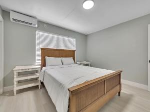 Un dormitorio con una cama grande y una ventana. en Modern Apt Near Beach – Views Wi-Fi, en Dania Beach