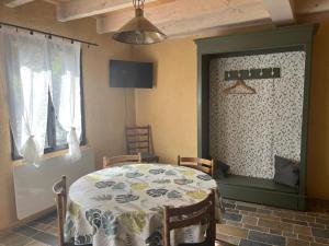 een eetkamer met een tafel en stoelen en een plafond bij La maison d olivier in Sébrazac