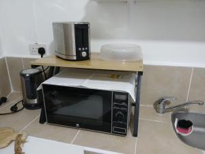 a microwave on a table with a coffee pot on it at Sun Kiss Retreat in Grand-Baie