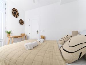 a bedroom with a large bed with towels on it at Casa Wanda in Estepona